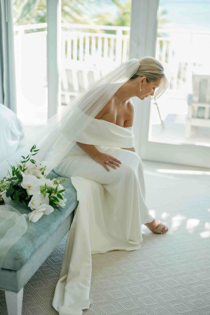 Beautiful Alissa- The Bride sitting on the sofa with a bouquet.